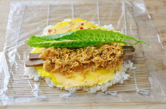 Bước 3: Rưới nước sốt salad lên mặt trứng sau đó cho vào cùng một lá ra diếp, 2 lát chả bò cùng chà bông.