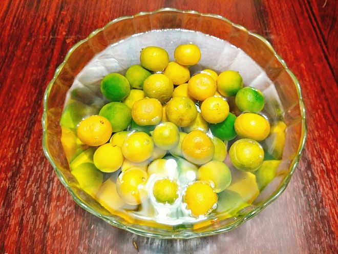 - Bước 1: Quất bạn nên chọn những quả chín vàng sẽ cho ra sản phẩm màu vàng đẹp mắt, rửa sạch quất sau đó cho vào âu nước muối loãng ngâm 30 phút, đổ ra sả lại cho sạch rồi để ráo nước.  