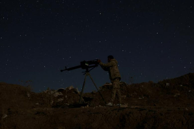   Một thành viên của quân đội Syria đang chiến đấu vào ban đêm ở thị trấn Dael, Syria, ngày 29/7. REUTERS / Alaa al-Faqir  