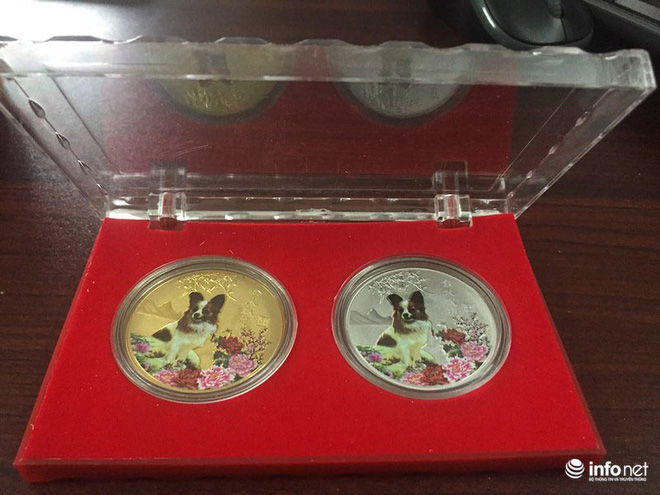Cặp tiền xu chạm nổi vẽ màu hình linh vật năm Mậu Tuất của Đài Loan được bán giá 100.000 đồng/bộ. Ảnh Infonet.