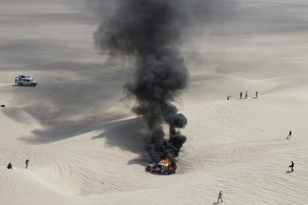   Chiếc xe Toyota của Alicia Reina và người đồng hành Carlos Dante Pelayo (Argentina) bị cháy tại vòng thứ ba tại sa mạc Pisco (Peru) trong cuộc đua Dakar 2018. Cả hai đã kịp thoát ra ngoài. Ảnh: Ricardo Mazalan / AP  