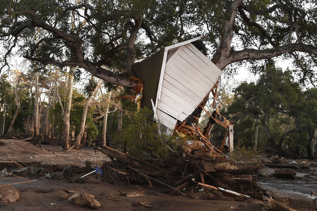   Một tòa nhà bị lũ bùn cuốn trôi và sau đó mắc kẹt vào một thân cây ở Montecito, một khu vực giàu có có khoảng 9.000 người sinh sống nằm ở phía Tây Bắc Los Angeles. Nơi này có những người nổi tiếng như Oprah Winfrey, Rob Lowe và Ellen DeGeneres. Ảnh: Robyn Beck / AFP  