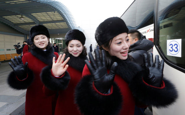 Các cô gái trong đội cổ động Triều Tiên vẫy tay khi có mặt tại văn phòng ở Paju, Hàn Quốc gần khu phi quân sự liên Triều (DMZ).