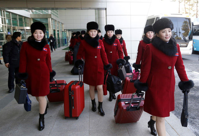 Ở độ tuổi ngoài 20, các cô gái đội cổ động Triều Tiên nở nụ cười thân thiện khi xuất hiện ở khu vực kiểm tra an ninh ở biên giới liên Triều.