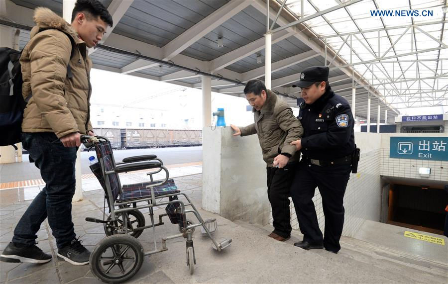 Một cảnh sát giúp đỡ hành khách đi vào ga đường sắt ở trạm Hàm Đan, tỉnh Hà Bắc.