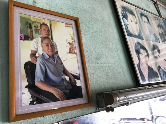 Anh Phong bảo quản cẩn thận tấm hình chụp chung với nguyên Thủ tướng và treo chính diện ở tiệm cắt tóc của mình.
