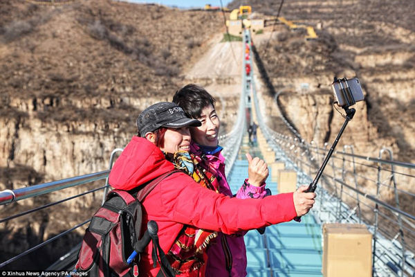 Các du khách không bỏ qua cơ hội selfie trên cây cầu treo đáy kính dài nhất thế giới này.