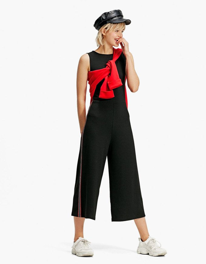 Xu hướng jumpsuit của năm nay là phần thân dưới suông rộng giống quần culottes nên không quá khó để chọn giày dép thích hợp đi kèm. Stradivarius cũng tung ra mẫu jumpsuit đen kẻ tăm có giá khoảng 650 nghìn đồng. 