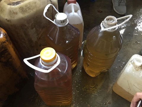 Hàng chục can dầu được múc lên từ giếng nước nhà anh Hải và được người dân đem về sử dụng bình thường.