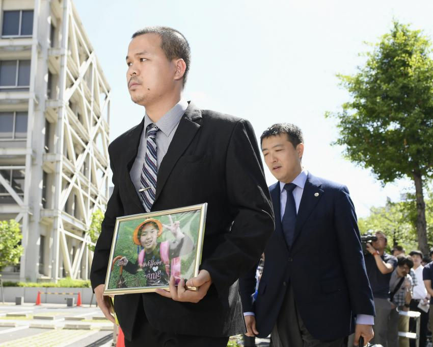 Cha của bé Nhật Linh mang di ảnh của con gái đến tòa án.  