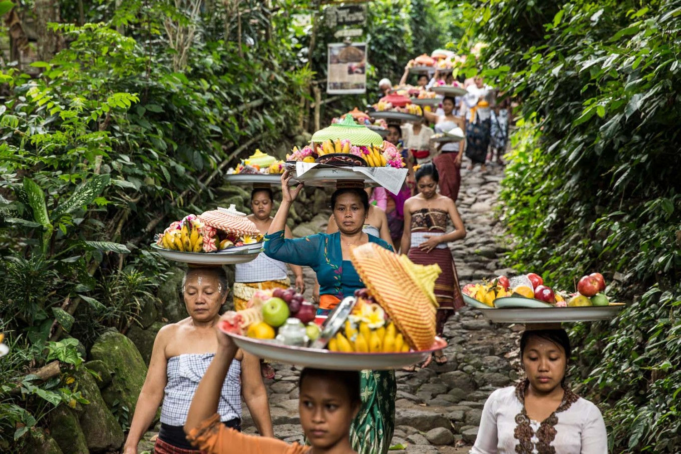 Những người phụ nữ đã có gia đình đội các lễ vật gồm hoa, quả và bánh truyền thống tới nơi tổ chức lễ hội.  