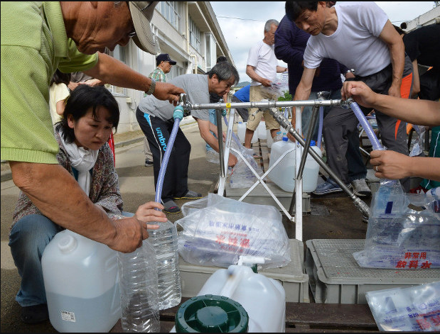 Những người dân sống trong vùng bị thiên tai được nhận nước sạch ở một địa điểm sơ tán tại thành phố Kurashiki, tỉnh Okayama.  