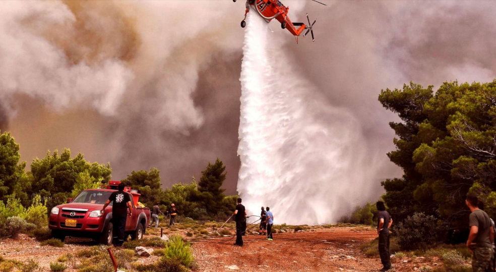 Một chiếc trực thăng cứu hỏa thả nước để dập tắt ngọn lửa của đám cháy ở làng Kineta, gần Athens, Hy Lạp  