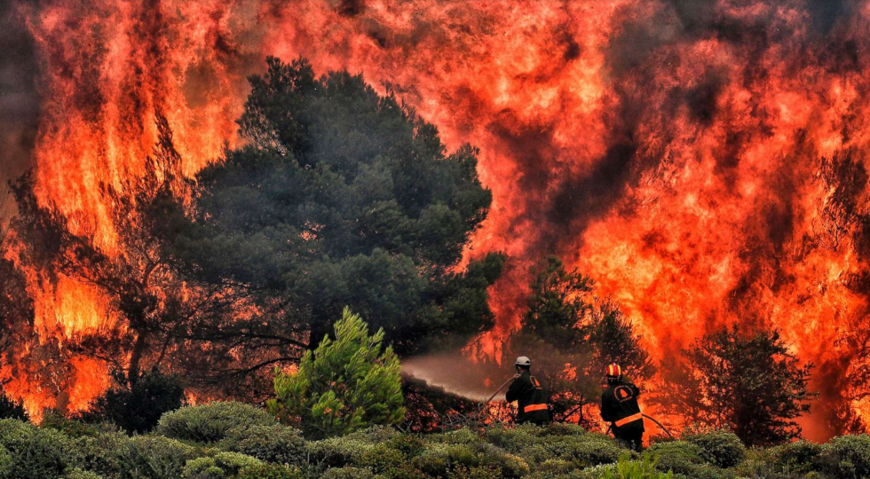   Nhân viên cứu hỏa cố gắng dập tắt ngọn lửa trong đám cháy ở làng Kineta, gần Athens, Hy Lạp.  