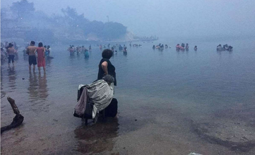   Mọi người cố gắng chạy ra biển để thoát khỏi ngọn lửa và khói khi cháy rừng ở Mati, Hy Lạp, hôm 23/7.  