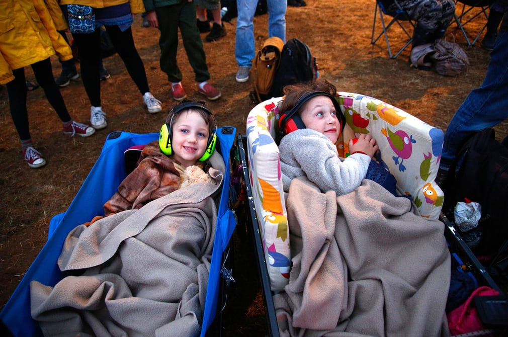   Hai người hâm mộ nhạc trẻ thư giãn trong xe cút kít tại lễ hội Womad, Wiltshire (Anh).  