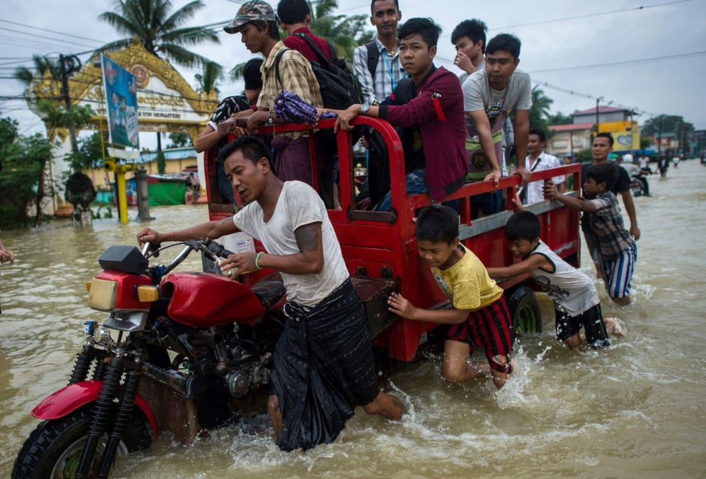 Người dân đẩy một chiếc xe qua dòng nước lũ ở bang Kayin, bang Mon và thành phố Bago (Myanmar).  