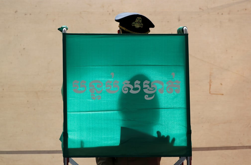 Một viên cảnh sát bỏ phiếu bầu cử trong cuộc tổng tuyển cử của Campuchia.  