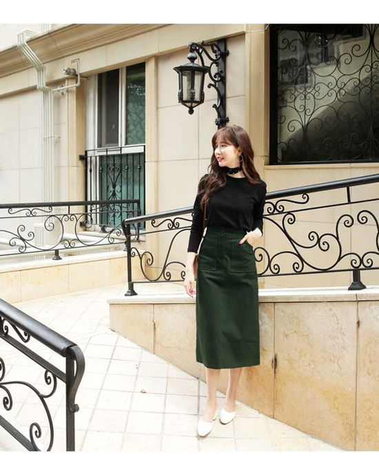 Áo đen kết hợp với váy xanh rêu và giày trắng tạo nên một tổng thể hài hòa xinh đẹp.