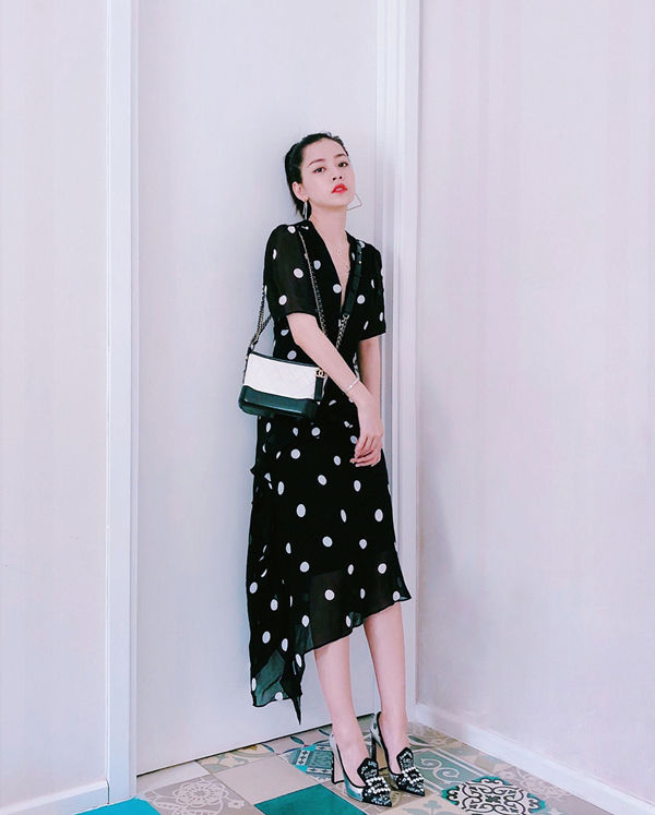 Đầm mang hơi hướng cổ điển với hoạ tiết chấm bi đen trắng được Chi Pu phối hợp nhịp nhàng cùng túi hiệu Chanel và giày mũi nhọn trang trí hoạ tiết bắt mắt.
