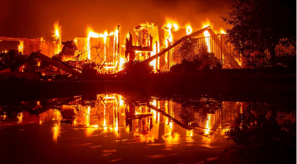   Một ngôi nhà đang bị ngọn lửa thiêu rụi dữ dội trong chiếc hồ bơi ở Redding, California.  