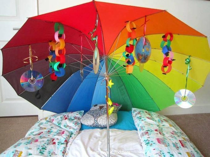 Nếu bạn cùng con chuẩn bị cho chuyến dã ngoại, đừng quên mang theo cây dù. Nó không chỉ giúp tránh nắng mà còn tạo nên bộ đồ chơi lung linh sắc màu. Ảnh: Learning and Exploring Through Play