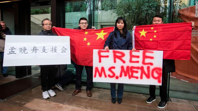 Những người ủng hộ giữ các biểu ngữ và cờ Trung Quốc bên ngoài tòa án ở Canada trong ngày thứ Ba của phiên điều trần tại ngoại cho Mạnh Vãn Châu