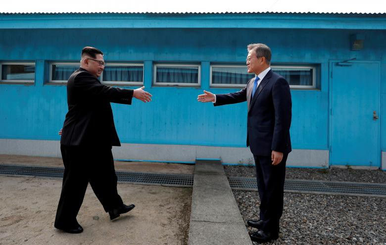 Cú bắt tay lịch sử giữa Tổng thống Hàn Quốc Moon Jae-in và Nhà lãnh đạo Triều Tiên Kim Jong-un tại Khu phi quân sự Triều Tiên. (Ảnh chụp ngày 27/4 bởi Korea Summit Press Pool)