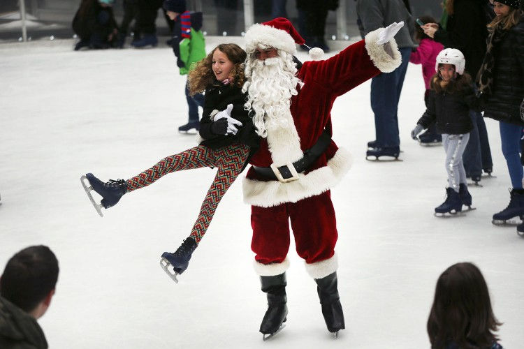 “Ông già Tuyết” bế bé gái tại sân trượt băng The Rink at Rockefeller Center, thành phố New York, Mỹ ngày 14/12. Ảnh: Getty