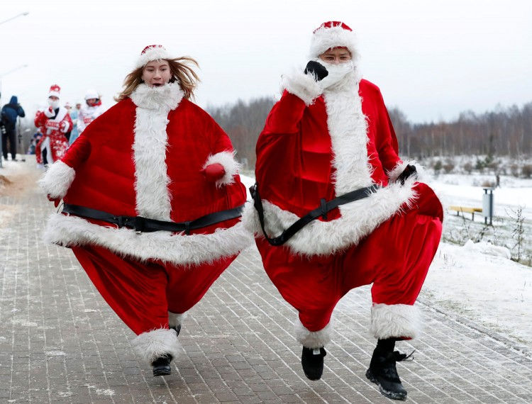 Người dân Belarus mặc trang phục ông già Noel chạy quanh hồ ở thủ đô Minsk khi tham gia sự kiện Santa Run lần đầu tiên được tổ chức ở quốc gia này hôm 15/12. Ảnh: Reuters