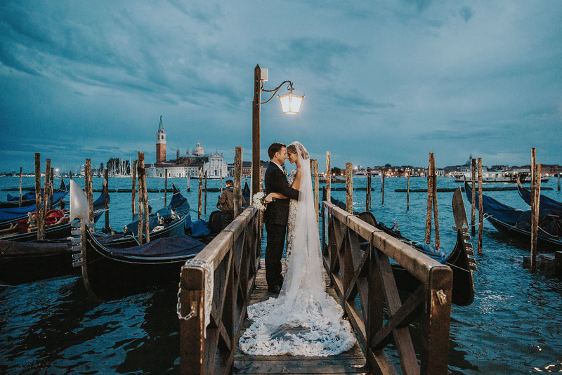 Khung cảnh Venice, Ý dập dìu sóng nước càng tôn lên sự tinh khôi của bộ váy cưới mà cô dâu đang mặc. Bức ảnh được chụp bởi nhiếp ảnh gia Natalie Watts.