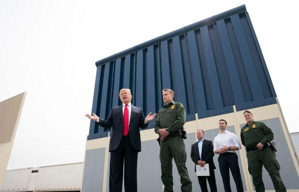 Tổng thống Trump đứng bên mẫu tường sẽ được xây ở biên giới Mexico.(Ảnh: New York Time)