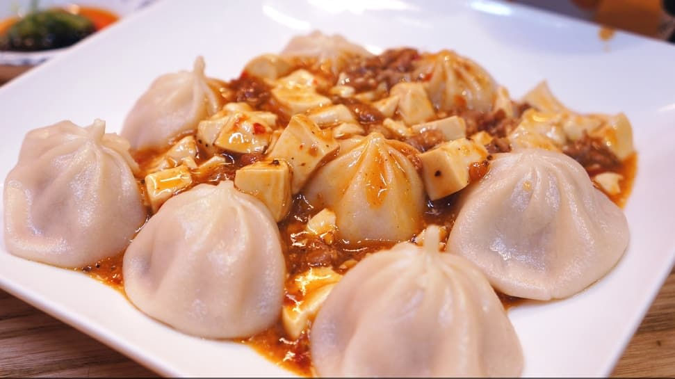   Món ăn này là sự kết hợp giữa những hương vị truyền thống của tiểu long bao (xiaolongbao) Thượng Hải và đậu phụ Tứ Xuyên. Trông có vẻ kỳ cục, nhưng sau cái “gấp đũa” đầu tiên, bạn sẽ mê mệt vì hương vị lạ lùng này đó. Ngoài ra tại đây còn có bánh bao chiên, bánh bao hấp truyền thống và nhiều món đặc biệt khác.  