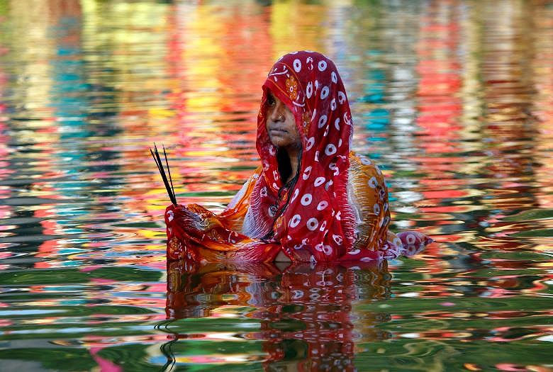 Một người phụ nữ Hindu làm lễ thờ thần mặt trời tại một hồ nước trong lễ hội tôn giáo Chhath Puja ở Agartala, Ấn Độ.