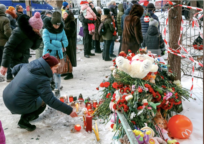 Người dân xung quanh tới đặt vòng hoa cho những người đã thiệt mạng. Ảnh: Reuters.