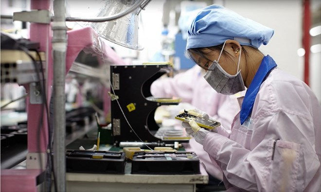 Công nhân làm việc trông dây chuyền sản xuất iPhone của Foxconn. Ảnh: macrumors