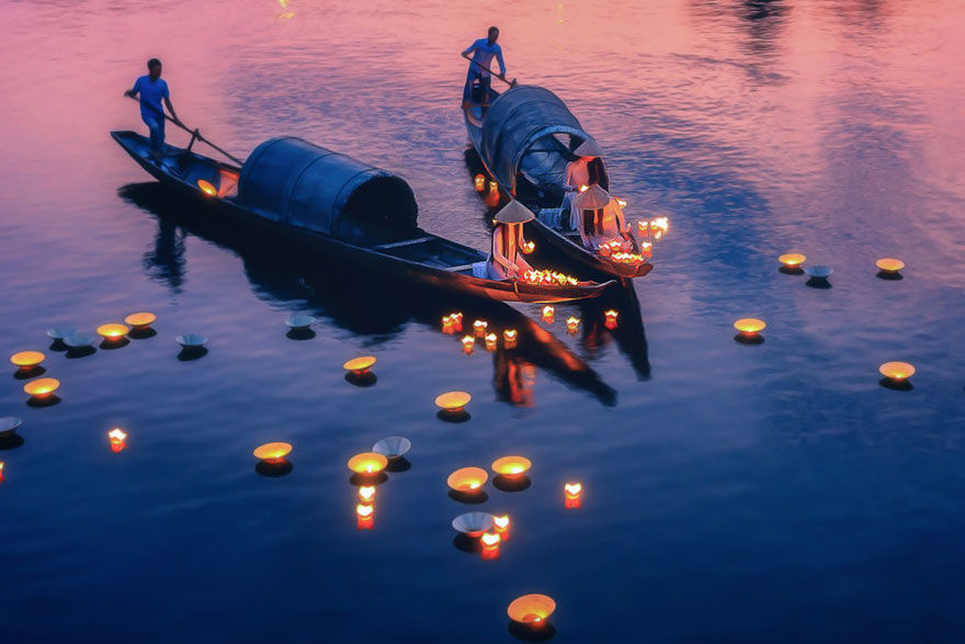 Trên sông Như Ý của Nguyễn Tuấn. Trên sông Như Y ở thành phố Huế, Việt Nam. Các cô gái mặc áo dài (trang phục truyền thống) đang thả những ngọn nến nổi trên sông để cầu nguyện cho hòa bình và hạnh phúc. Đây là văn hóa tinh thần lâu đời ở Việt Nam