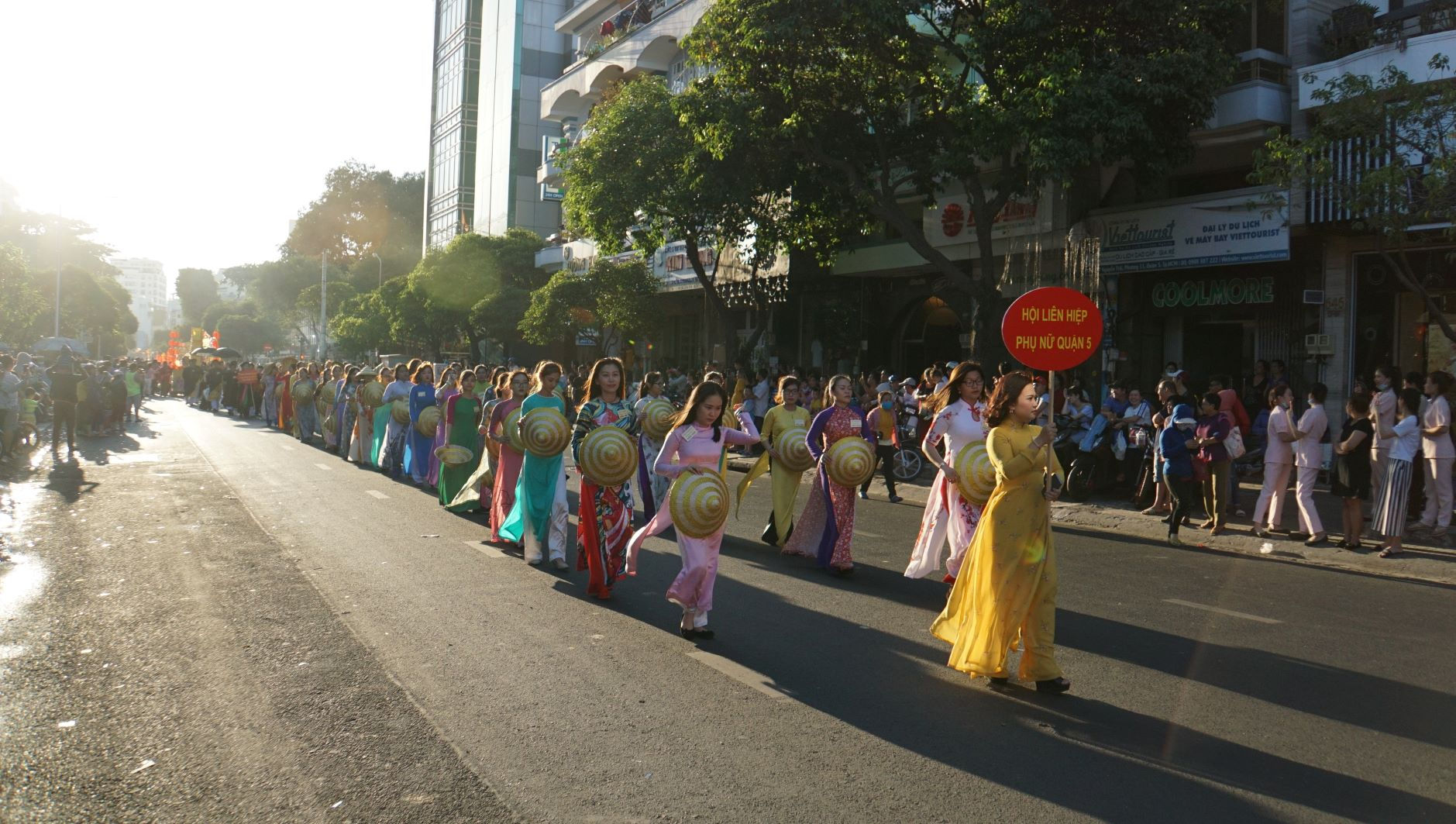  Tham gia đoàn diễu hành còn có các cô gái trong trang phục áo dài, nón lá.