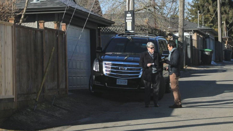 Phóng viên của tờ South China Morning Post, Ian Young (phải) giới thiệu mình với một trong những người bảo vệ của Mạnh Vãn Châu ở phía sau nhà cô ở Vancouver vào ngày 9/3.