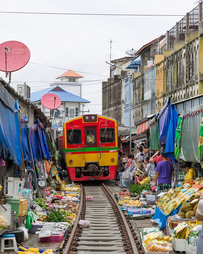 18. Chợ đường sắt Maeklong ở Bangkok, Thái Lan được đặt trực tiếp trên đường ray xe lửa và đoàn tàu đi qua chỉ cách vài cm trước các quầy hàng. 