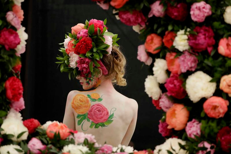 Người mẫu tạo dáng với thiết kế hoa mẫu đơn bằng hoa tươi và sơn màu. Ảnh: Matt Dunham. 