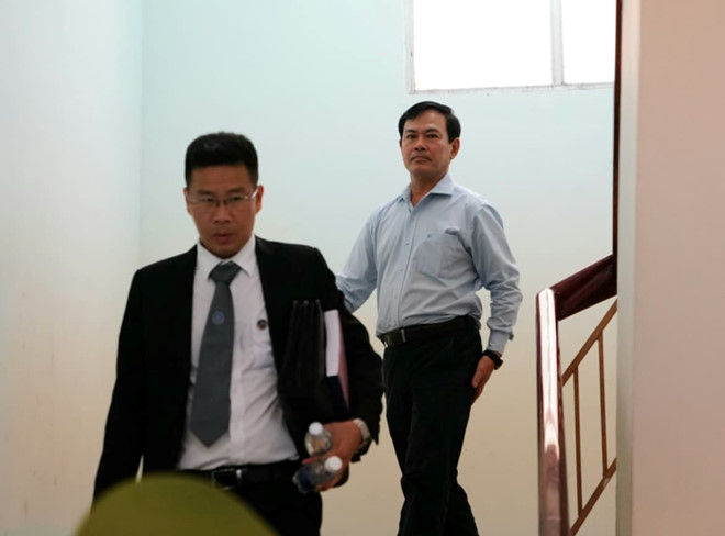 Bị cáo Nguyễn Hữu Linh (đi sau) và luật sư bào chữa, rời tòa sau khi hoãn xét xử.