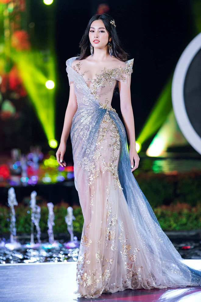 Hoa hậu Tiểu Vy xuất hiện với bộ trang phục đầm đuôi cá, dáng ôm sáng, họa tiết đính kết sequin, kim tuyến lấp lánh tạo điểm nhấn. 