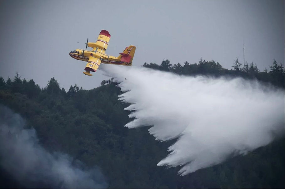   Theo chính quyền địa phương, đám cháy ngày 15/8 đã phá hủy 900 ha rừng thông ở miền Nam nước Pháp. Trong hình: Một chiếc máy bay cứu hỏa xả nước để dập tắt đám cháy rừng đang hoành hành gần làng Monze ở miền nam nước Pháp, ngày 15/8. Ảnh: Getty Images.  