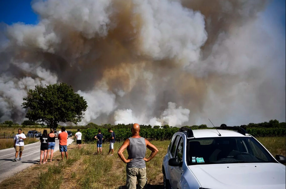   Người dân đang nhìn một đám cháy rừng ở vùng nông thôn xung quanh Vauvert, miền Nam nước Pháp, ngày 2/8. Ảnh: Getty Images.  