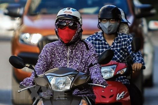 Người dân ra đường trong trang phục kín mít để bảo vệ bản thân vì khói bụi và ô nhiễm không khí. (Ảnh: Trọng Đạt/TTXVN)