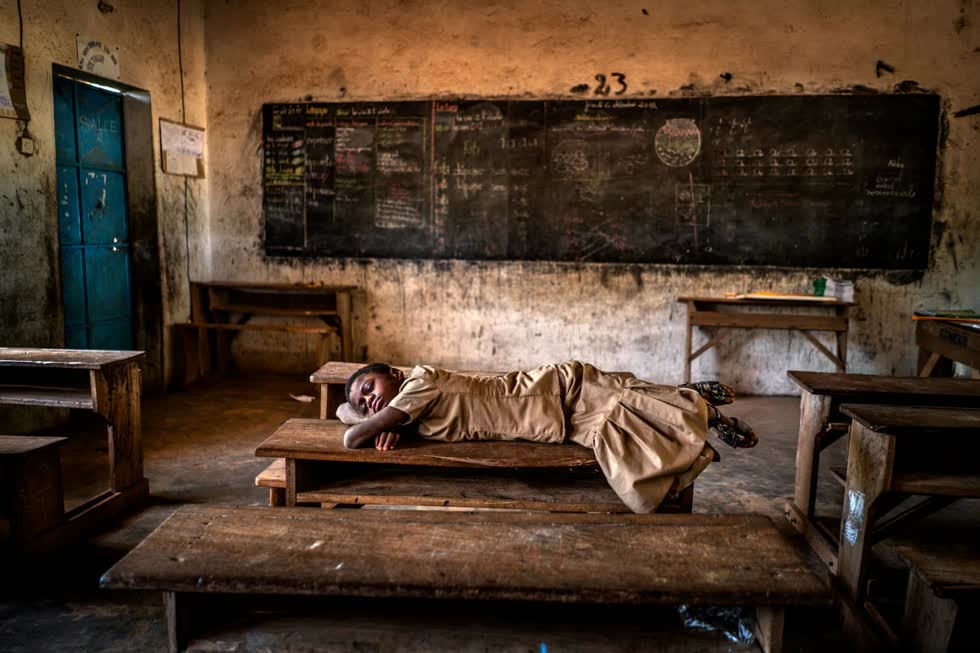   Một cô gái ngủ trên bàn trong phòng học của mình. Những cơn mưa đã tăng gấp ba lần ở Sahel trong 35 năm qua vì sự nóng lên toàn cầu. Biến đổi khí hậu đã gây ra 70 đợt mưa lớn trong thập kỷ qua mặc dù khu vực này cũng chịu hạn hán nghiêm trọng. Ảnh: Aragon Renuncio.  