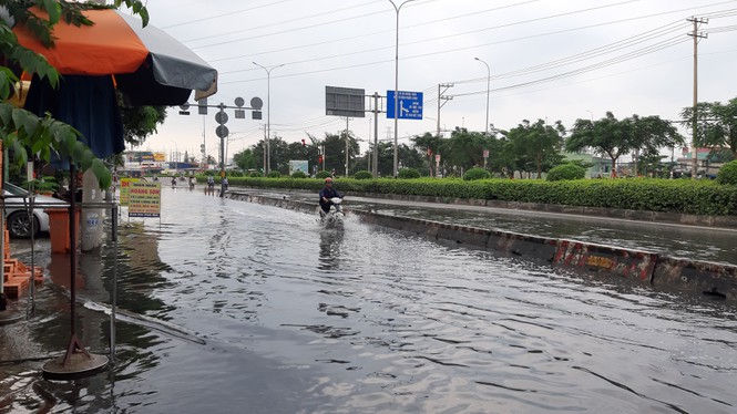 Nước tràn vào nhiều tuyến đường ở các quận: 1, 7, 8, quận Bình Tân, Bình Thạnh, huyện Nhà Bè... khiến các phương tiện lưu thông thông gặp nhiều khó khăn. Ảnh: báo Tiền Phong