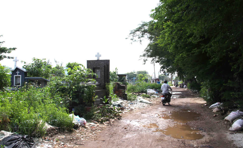 Những con đường bên trong nghĩa trang đầy ổ gà, người dân vứt đầy rác hai bên.