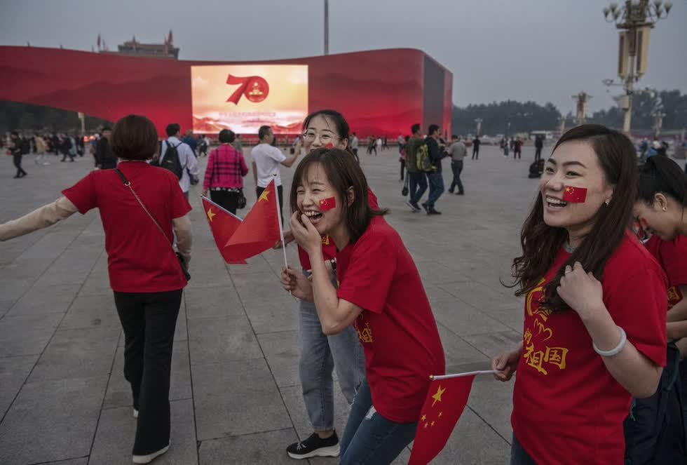 Người dân Trung Quốc tay cầm cờ, mang áo kỷ niệm 70 năm quốc khánh tới buổi lễ. Ảnh: SCMP.